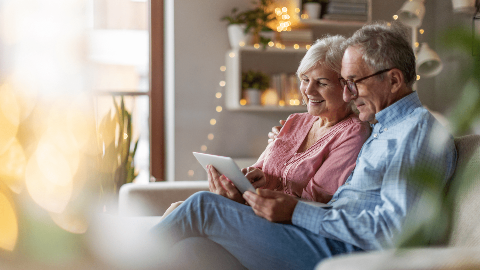Couple-looking-at-tablet-on-couch